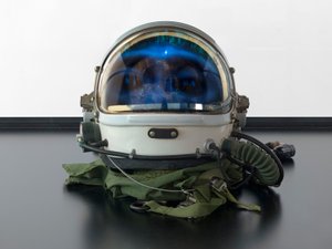 Alpha Omega, 2016 (cristal, pantalla LCD, reproductor multimedia, réplica de una calavera, casco espacial, madera) de Mat Collishaw