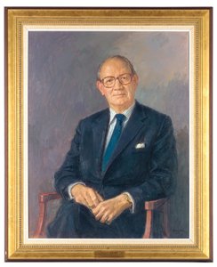 Retrato de Lord Aldington, sentado con traje oscuro de Michael Noakes