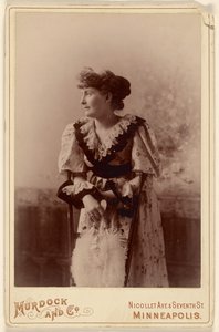 [Mujer no identificada de perfil, apoyada en una silla, sosteniendo un abanico de plumas] de Murdock and Company