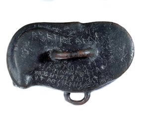 Peso votivo en bronce en forma de osselet con una dedicación en griego a Apolo de Didymus, votivo al templo del dios en Mileto. Periodo Routenide. Reportado como botín por Darío I. encontrado en el sitio de Susa. París. Museo del Louvre de Persian School