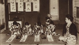 Escolares japonesas escribiendo con pinceles en una clase de jardín de infantes