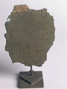 Lex Tappula, fragmento de ley satírica redactada por círculo convivial de Vercelli, parodia escrita en la misma forma que las leyes plebiscitarias romanas, formando parte de las leges conviviales transmitidas por Festo, bronce, civilización romana