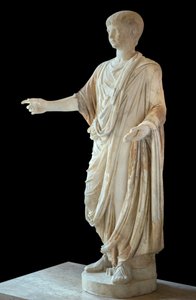 Niño vestido con toga y llevando la bulla, la cabeza es la de Nerón niño