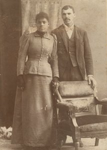 Fotografía de una pareja afroamericana de pie detrás de una silla, ca. 1890 de Schmitz Studio
