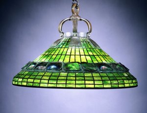 Una lámpara de araña de vidrio emplomado y azulejos de caparazón de tortuga y bronce de School American
