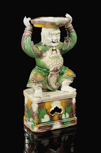 Candelabro esmaltado de huevo y espinaca, modelado como un inmortal sonriente con barba rizada, brazos levantados para sostener el accesorio de candelabro de cuatro hojas equilibrado en su cabeza, Kangxi de School Chinese