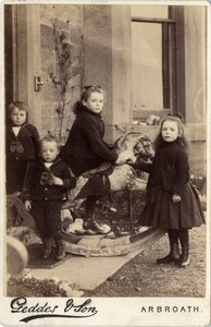 Grupo de niños pequeños y su caballo de juguete de Scottish Photographer
