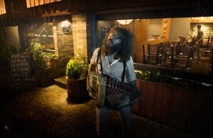 Músico en una noche lluviosa