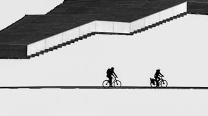 Ciclistas en silueta en las escaleras de Shanrui Ren