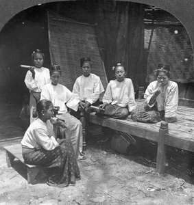 Mujeres birmanas fumando fuera de su casa, Mandalay, Birmania, 1908