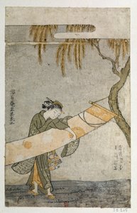 Joven mujer atendiendo un kakemono atado a un árbol