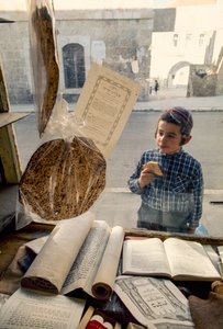 Niño judío conservador comiendo tarta se asoma a una librería religiosa. de Ted Spiegel
