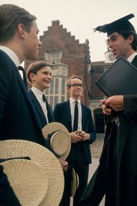 Alumnos de Harrow consultan con un profesor delante de su escuela.