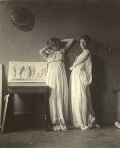 Dos modelos femeninas en traje clásico con la escultura 