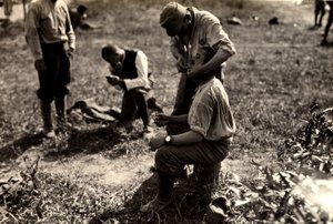 Prisioneros austriacos durante la Primera Guerra Mundial en Bagnaria Arsa, Udine, Italia; en primer plano un soldado afeita a un compañero, 02/04/1916 (foto b/n)
