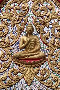 20151102, Vang Vieng, Laos: Puerta de entrada ornamentada con relieves dorados. El Buda enseñando representa un momento particular en la vida del Buda, a saber, el primer sermón que dio después de alcanzar la Iluminación de Unbekannt