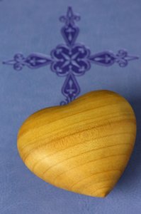 Corazón tallado en madera sobre una Biblia Sagrada