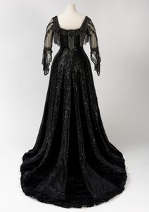 Vestido de noche negro de longitud completa usado por la Reina Alexandra, con decoración de cuentas y lentejuelas e incorporando la cinta de nombre de seda negra y letras doradas de la Reina Alexandra, hecho por Barolet de Knightsbridge, Londres 1908-1910
