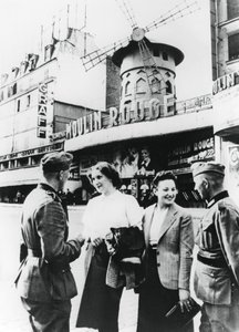 Soldados alemanes coqueteando con mujeres francesas fuera del Moulin Rouge, París ocupado, junio de 1940 de Unbekannt