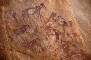 Arte rupestre, Prehistoria: Pintura de un grupo de ganado y personajes en un refugio ornamentado, en el macizo de Uweinat, Sudán (Karkur-Talh o Karkur Talh). Período de 8000 a 3000 años a.C. Fotografía de Unbekannt