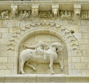 Arte románico: detalle de la fachada que representa a Hugues de Surgeres y Geoffroy de Vendome o al emperador Constantino I el Grande cuyo pie del caballo pisaría la herejía y Cristo triunfante del mal y la muerte, Notre Dame de Surgeres de Unbekannt