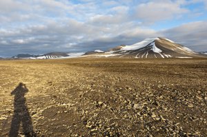 Sombra de un humano, suelo estructural poligonal en el Plataberget, pico nevado Nordenskjoeldfjellet en el fondo, cerca de Longyearbyen, Spitsbergen, Svalbard, Noruega, Europa de Unbekannt