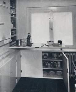 Werner Harting - Cocina con suelo de baldosas negras holandesas, paredes blancas y estantes y armarios empotrados de Unbekannt