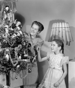 Mujer y niña decorando un árbol de Navidad, c. 1948