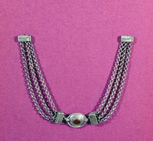 Collar de plata con cornalina, en un engaste ovalado bordeado con un moldeado de cable, suspendido entre dos longitudes de tres cadenas sujetas por un broche tipo caja, encontrado en Great Chesters, mediados del siglo I de Unbekannt Unbekannt
