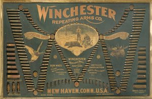 Tablero de exhibición de cartuchos Winchester, con una selección completa de cartuchos de rifle metálicos, de latón y de papel dispuestos en forma de una "W" extendida de Unbekannt
