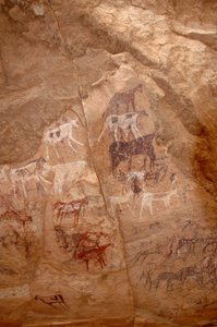Arte rupestre, Prehistoria: Pintura rupestre de un grupo de ganado y personajes en un refugio ornamentado, en el macizo de Uweinat, Sudán (Karkur-Talh o Karkur Talh). Periodo de 8000 a 3000 años a.C. Fotografía de Unbekannt