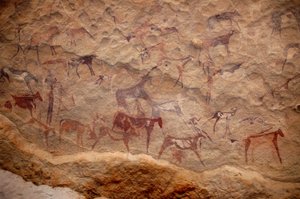 Arte rupestre, Prehistoria: Pintura rupestre de un grupo de ganado y personajes policromos (pastores y arqueros) en un refugio ornamentado, en el macizo de Uweinat, Sudán. Período de 8000 a 3000 años a.C. Fotografía de Unbekannt