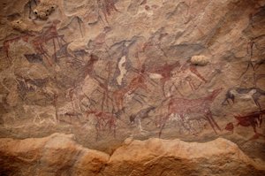 Arte rupestre, Prehistoria: Pintura rupestre de un grupo de ganado y personajes policromos en un refugio ornamentado, en el macizo de Uweinat, Sudán. Período de 8000 a 3000 años a.C. Fotografía de Unbekannt
