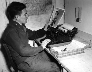 Segunda Guerra Mundial (1939-1945): Mutzig (Alsacia) Francia 1 de diciembre de 1944: El cabo Flanerty cronista del Beachead News (periódico de noticias de los GI) mira una fotografía de pin-up que publicará en el próximo número del periódico