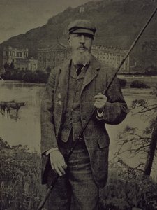 Retrato de estudio del 8º Duque de Devonshire con ropa de tweed sosteniendo una caña de pescar frente a una pantalla impresa que representa Chatsworth de William M. Timlin