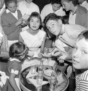 La actriz y modelo Elsa Martinelli en el XVIII Festival Internacional de Cine en el Lido de Venecia (firma autógrafos con jóvenes fans. En la mesa, una botella de Schweppes) - 1957 de Unbekannt