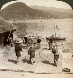 Trillando cebada junto a una playa de pesca en el Mar Interior, Japón, 1904 de Underwood and Underwood