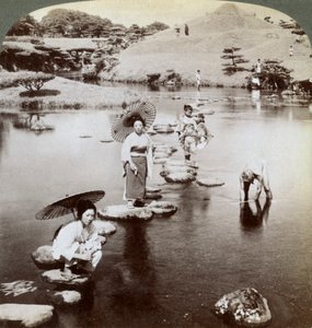 Mujeres cruzando el lago sobre piedras, Jardín Suizen-ji, Kumamoto, Japón, 1904 de Underwood and Underwood
