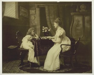 Mujer y niño jugando al dominó en la mesa de Unknown