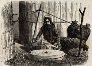 Mujer turcomana usando la rueda de moler grano, activando un ingenioso sistema de manivela, la piedra superior gira y al frotar esta piedra sobre la otra tritura los granos, que forman la base de la dieta turcomana, en forma de pan, hervidos, empanadas. Gr de Unknown artist