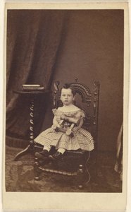 [Niña no identificada sosteniendo un caballo de madera de juguete, sentada] de Unknown artist