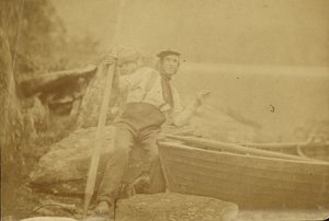 [Hombre posando junto a bote de remos]