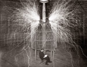 Nikola Tesla sentado en su laboratorio de Colorado Springs con su “Transmisor Magnificante” de Unknown photographer