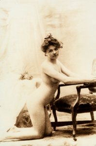 Retrato desnudo de una mujer joven arrodillada delante de un pequeño sillón. de Unknown photographer