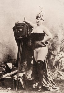 Retrato de una mujer parcialmente desnuda apoyada en una cámara antigua. de Unknown photographer
