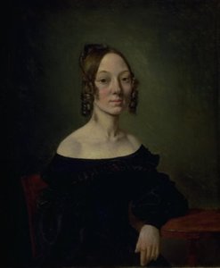 Retrato de una niña con un vestido negro sentada a la mesa