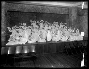 Grupo de niñas pequeñas posando en un pequeño escenario con abanicos, probablemente el Orfanato Católico Romano, Kingsbridge, Bronx, c.1911 de William Davis Hassler