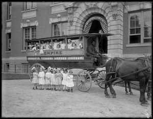 Niñas pequeñas posan en y frente a un carro tirado por caballos, frente a un edificio no identificado, probablemente el Asilo de Huérfanos Católico Romano, Kingsbridge, Bronx, c.1910 de William Davis Hassler