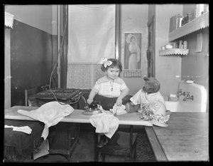 Niña no identificada demostrando el uso de una plancha eléctrica, c.1913-14