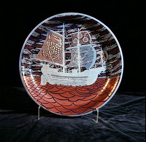 Plato con lustre plateado, con un galeón navegando en un mar de lustre rojo de William de Morgan